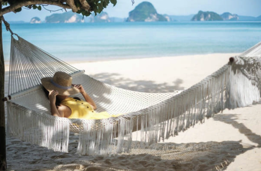 A person relaxing in a hammock on a beautiful Bali beach, contemplating extending their stay.